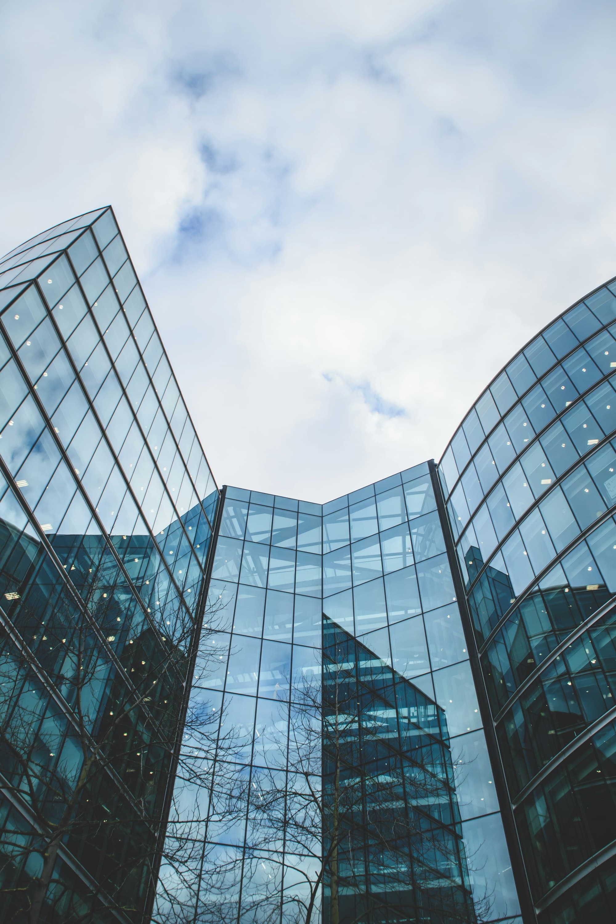 Modern glass office building against a pale sky