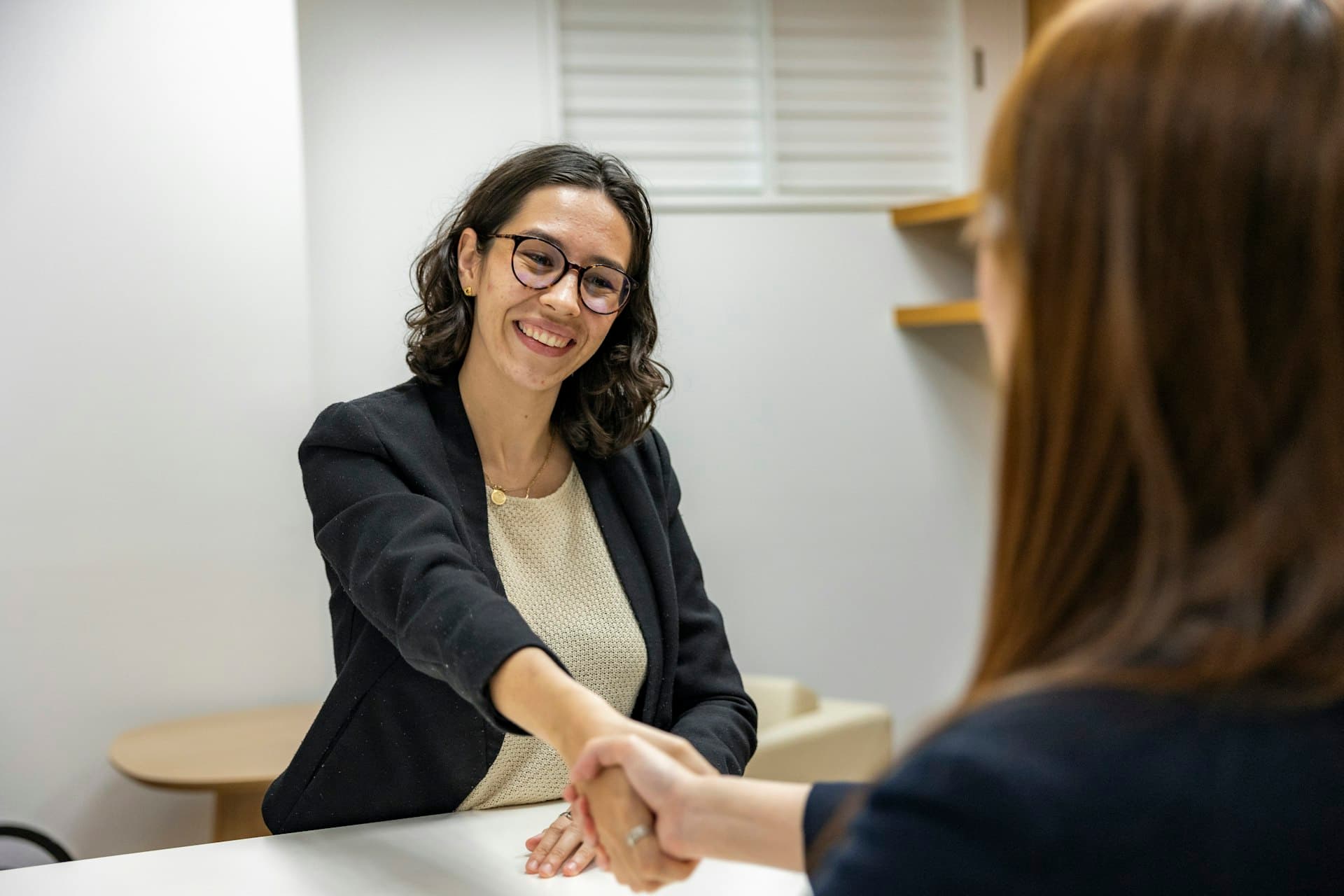 An admissions advisor welcoming a student with a handshake
