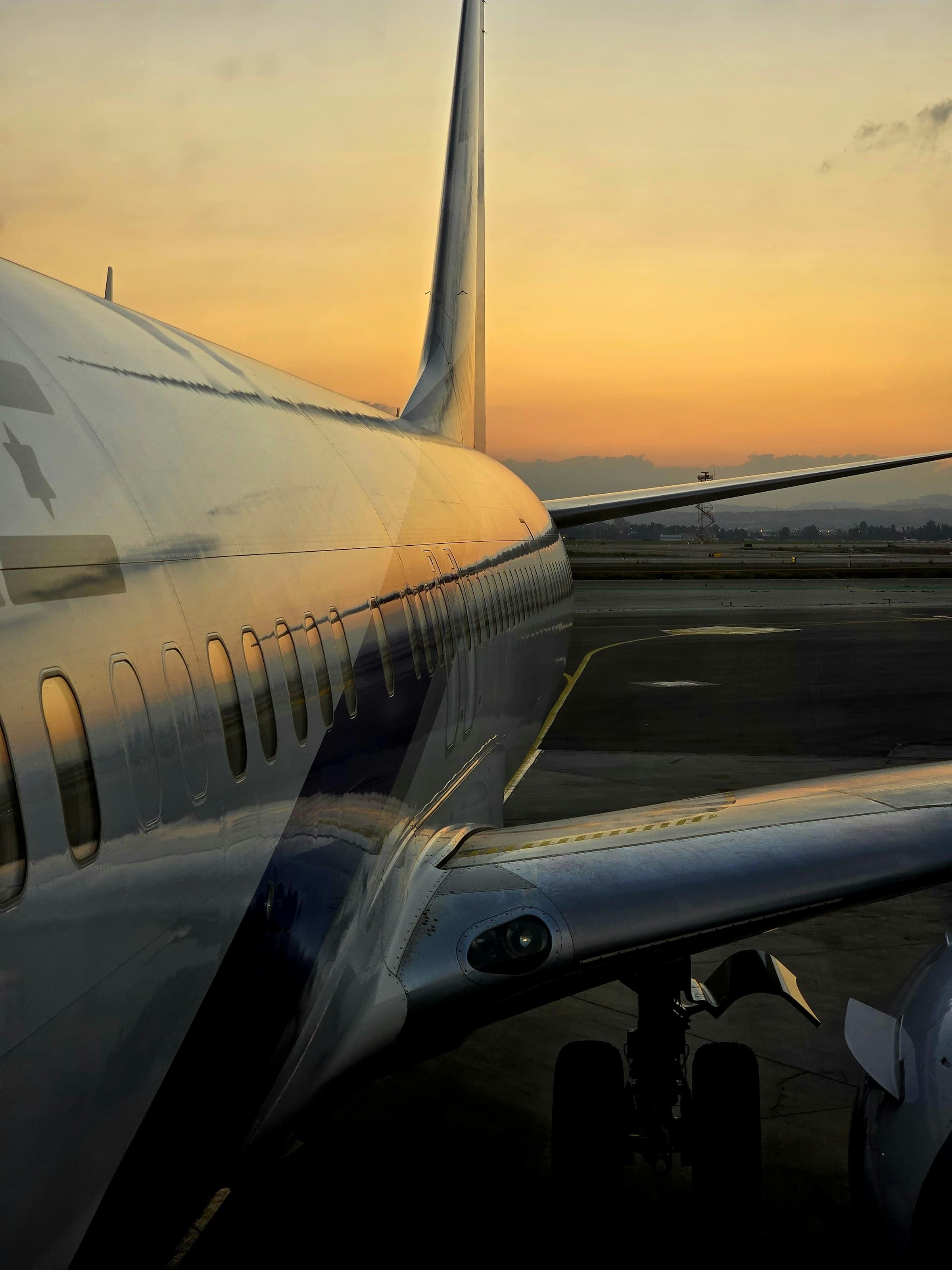 A passenger aircraft glowing in golden-hour light on the tarmac