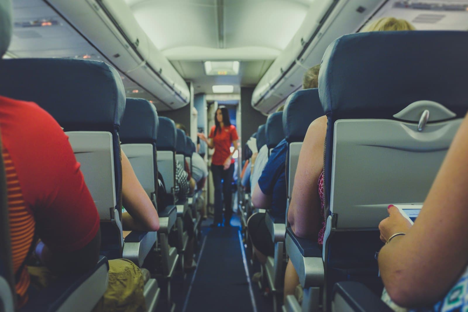 A cabin crew member walking the aisle attending to passengers